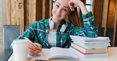 Ragazza seduta alla scrivania con libri