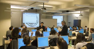 Aula di economia con computer, studenti e professori