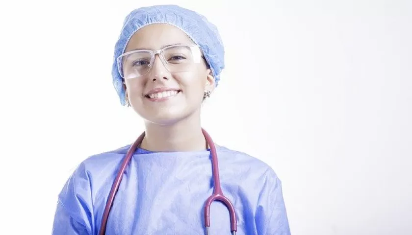 Ragazza con camice azzurro, stetoscopio e occhiali protettivi
