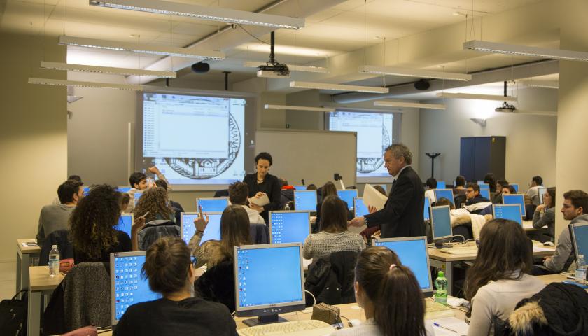 Aula di economia con computer, studenti e professori