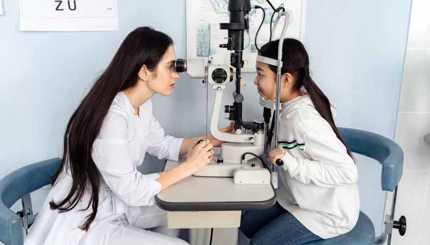 oculista con strumento che prova la vista a una bambina