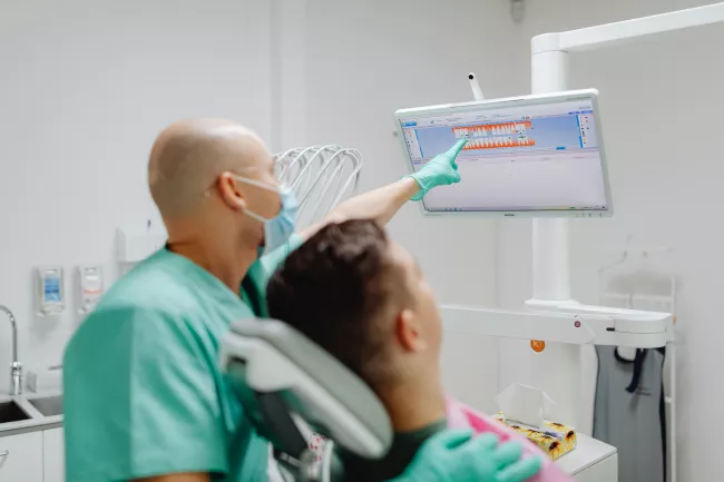 Dentista o igienista dentale che interagisce con un paziente durante una consultazione