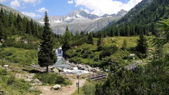 Una pittoresca vista di una cascata in Val Camonica con le montagne alpine sullo sfondo